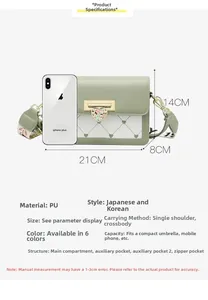 Détail de la boucle en métal en forme de cœur sur un sac à bandoulière à carreaux vert