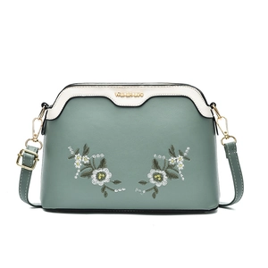 Green and cream shell-shaped crossbody bag with floral embroidery and gold logo