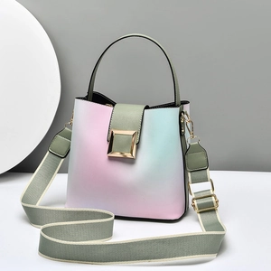 Pink blue gradient bucket bag with wide woven strap and gold buckle in a minimalist design