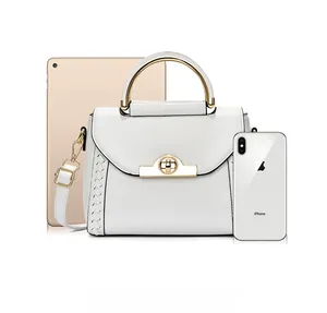Compact white crossbody bag with gold handle shown next to iPad for size comparison