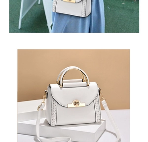 Detail of white leather handbag featuring metal circular handle and woven side textures