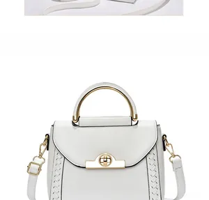 Detailed front view of white leather handbag with golden metal handle and woven sides