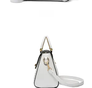 Side view of white PU leather handbag with black trim and gold ring hardware