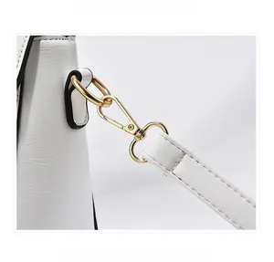 Detailed close-up of premium white leather texture and polished gold metal lobster clasp