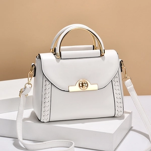 Minimalist white leather handbag with golden metal handles and woven side textures