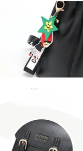 Détail d'un sac à dos noir en cuir PU avec boucle en métal et charm de dessin animé