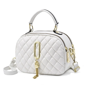White quilted crossbody bag with dual zippers, gold hardware, and tassel detail