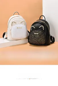 Detail of cat ear design on mini sequined backpack with rhinestone accents and logo