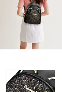 Close-up of sparkling sequin surface and golden cat-ear hardware on black mini backpack