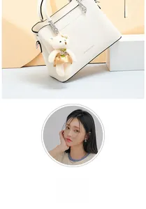 Détail du sac à main blanc en cuir avec lettrage JING&PIN et charm ours en peluche