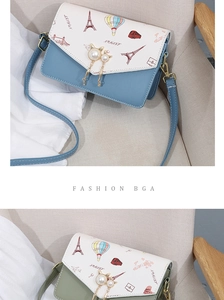 Detail of crossbody bag with Eiffel Tower illustration and pearl cat charm decoration