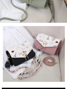 Detail of the cute cat pearl charm and printed Eiffel Tower design on a leather handbag