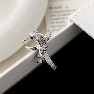 Silver bow ear cuff with micro-p鑲ed cubic zirconia stones on minimalist display