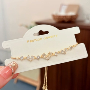 Dettaglio del bracciale dorato con zirconi a cuore e chiusura a scorrimento regolabile