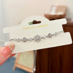 Nahaufnahme eines verstellbaren Silber-Schneeflockenarmbands mit Zirkon-Steinen auf Karte