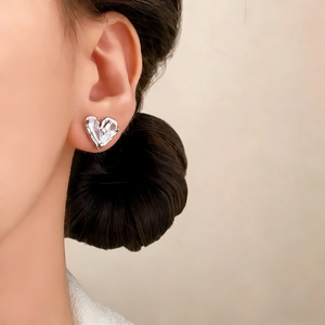 Boucles d'oreilles cœur argentées avec texture métal liquide portées par un mannequin