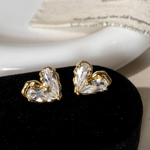 Gros plan détaillé des boucles d'oreilles cœur dorées ornées de zircons étincelants
