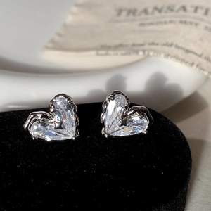 Détail de boucles d'oreilles cœur en argent avec zircon et motif d'étoile