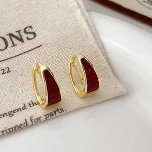 U-shaped gold-plated hoop earrings with dark red enamel in a minimalist vintage style
