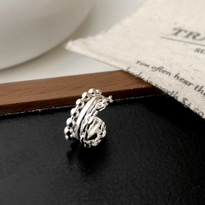 Detailed macro view of multi-layered silver ring featuring bead and twisted rope textures