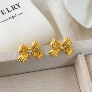 Vue détaillée des boucles d'oreilles nœud dorées texturées avec pierre en zircone marquise