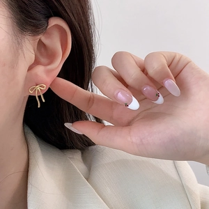 Elegant gold bow earrings for women featuring a minimalist knot design on model