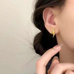 Elegante goldene Schleifen-Ohrstecker für Damen, am Model gezeigt für den Alltag