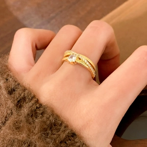 Elegant gold ring with a large central zircon and multi-row textured pavé band