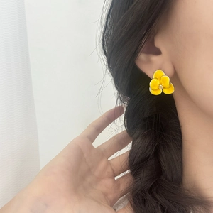 Elegant yellow enamel flower stud earrings with metallic edges and shimmering center