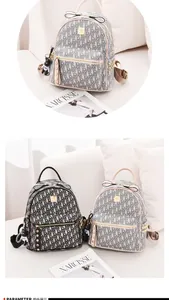 Detail of monogram leather backpacks in black and beige with cute bear charm