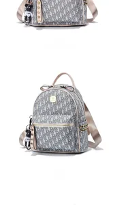 Detail of monogram backpack featuring gold studs and a black teddy bear pendant accessory