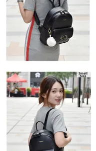 Detail of small black quilted faux leather backpack with white pompom and cat charm