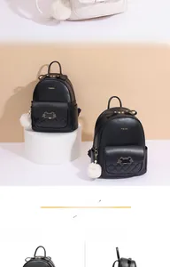 Close-up of black leather backpack featuring a cat metal clasp and white fur ball pendant