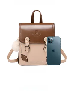 British style backpack in brown and beige faux leather showing size scale with phone