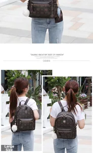 Detail eines dunkelbraunen Lederrucksacks mit Vintage-Kronenmonogramm und weißem Pelzanhänger