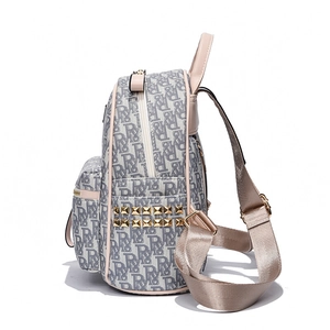 Gray monogram canvas backpack with pink leather trim and gold studs on side view