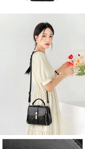 Close-up of black crossbody bag featuring elegant vertical quilted texture and gold clasp