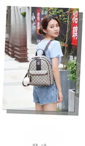 Outdoor shot of a vintage patterned beige backpack with brown leather strap and plush ball charm