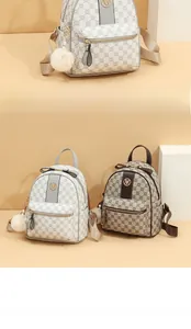 Detail of mini fashion backpacks with monogram texture and plush ball charms