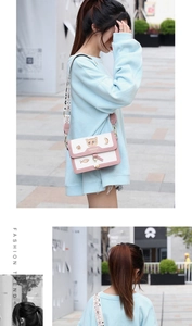 Détail du sac bandoulière rose et blanc avec broderie chat et sangle en jacquard