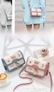 Détail de la broderie chat et des breloques sur un petit sac bandoulière tendance