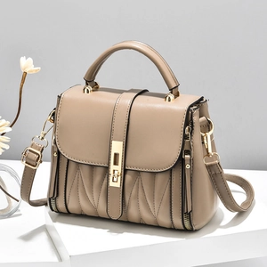 Minimalist striped crossbody handbag with gold clasp on white geometric pedestal