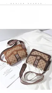 Detail of vintage crossbody bag featuring canvas monogram pattern and striped strap