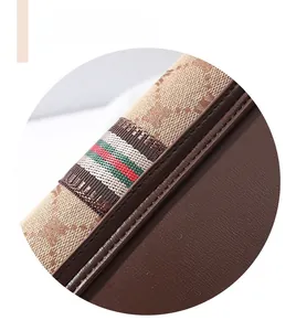 Detail of stitched brown leather and monogram canvas with iconic striped web accent