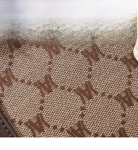 Close-up of premium brown monogram jacquard fabric with durable leather trim detailing