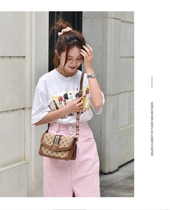 Brown leather crossbody bag with vintage monogram patterns and adjustable shoulder strap