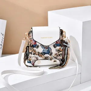 Detail of white bear print envelope bag featuring a decorative striped silk scarf handle