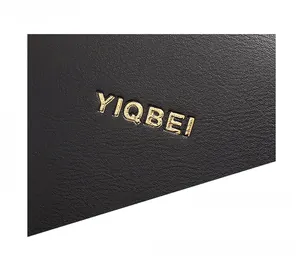 Gros plan sur le cuir grainé noir avec un logo doré embossé de haute qualité