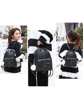 Détails du sac à dos en cuir souple noir montrant les modes de port et le pompon blanc