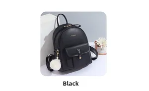 Détail du sac à dos en similicuir noir avec poche frontale et pompon blanc en peluche